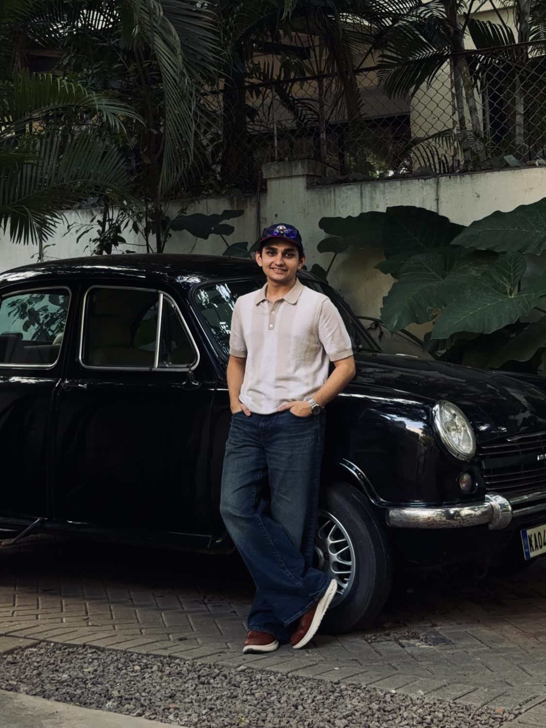 Kaneshk leaning on a black Ambassador car